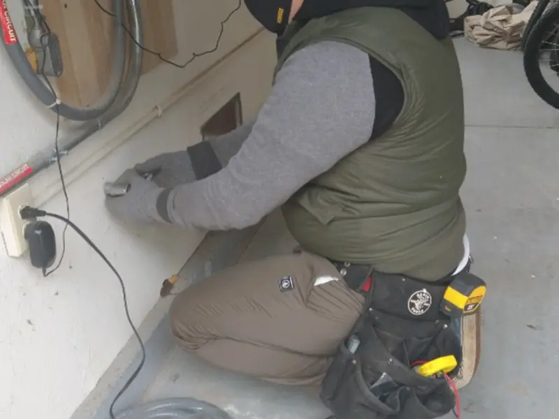 Electrician performing outlet wiring in a West Brookfield garage